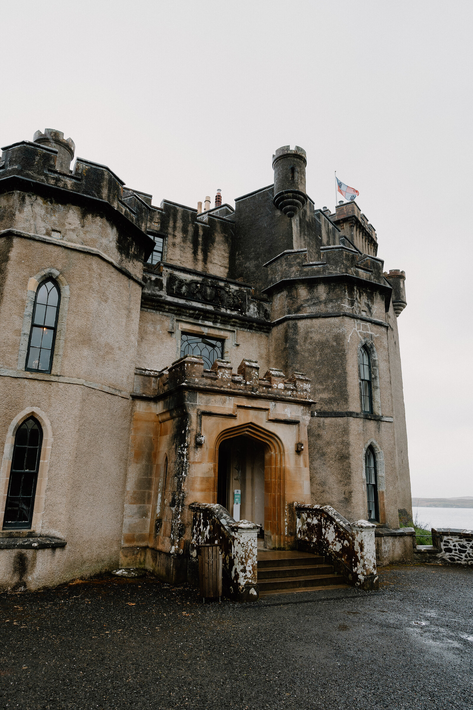 A flight of worn stone steps leads up to Dunvegan Castle's arched entrance between two turrets.