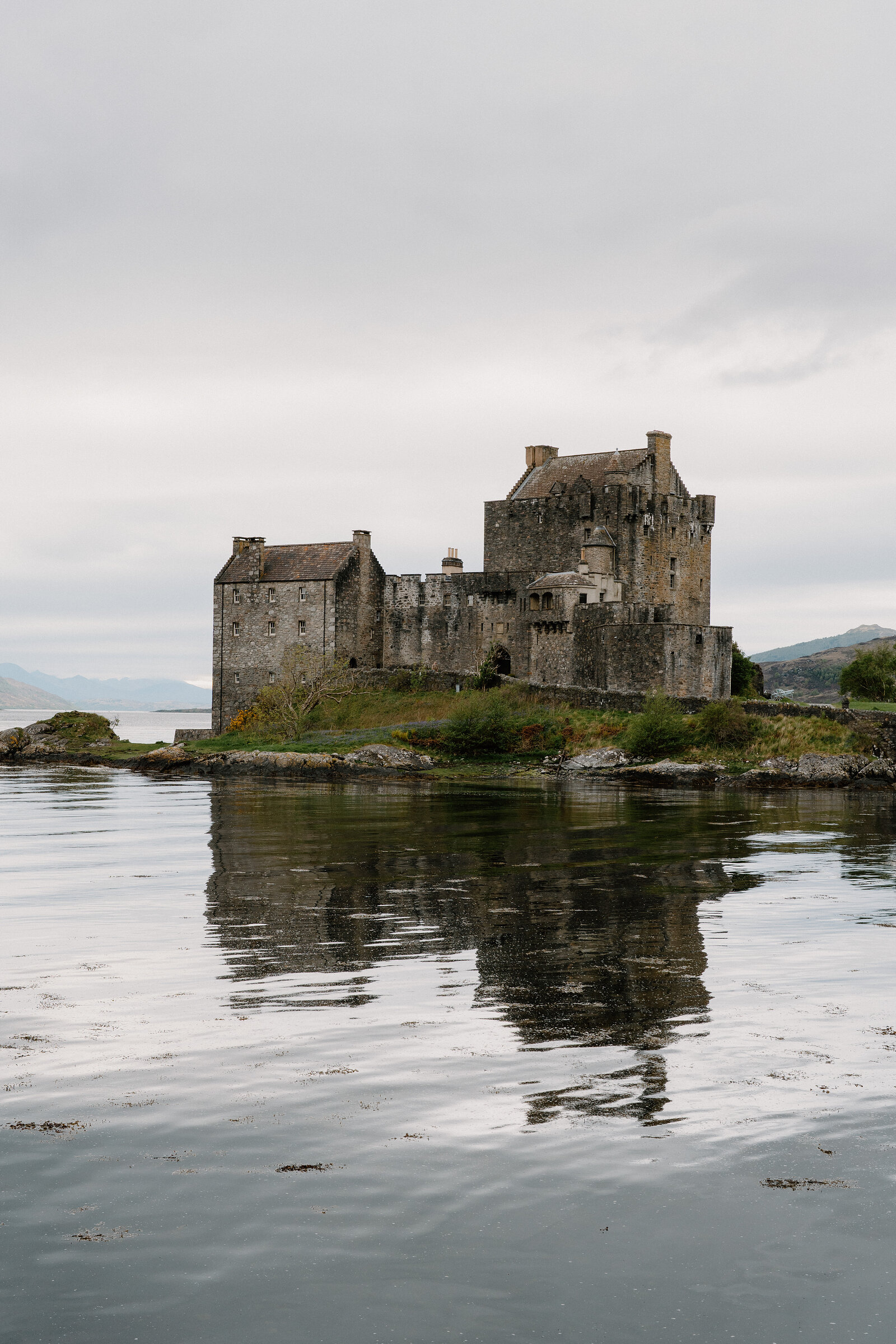 Eilean Donan Castle stands on its tidal islet, mirrored in the still water of the loch.