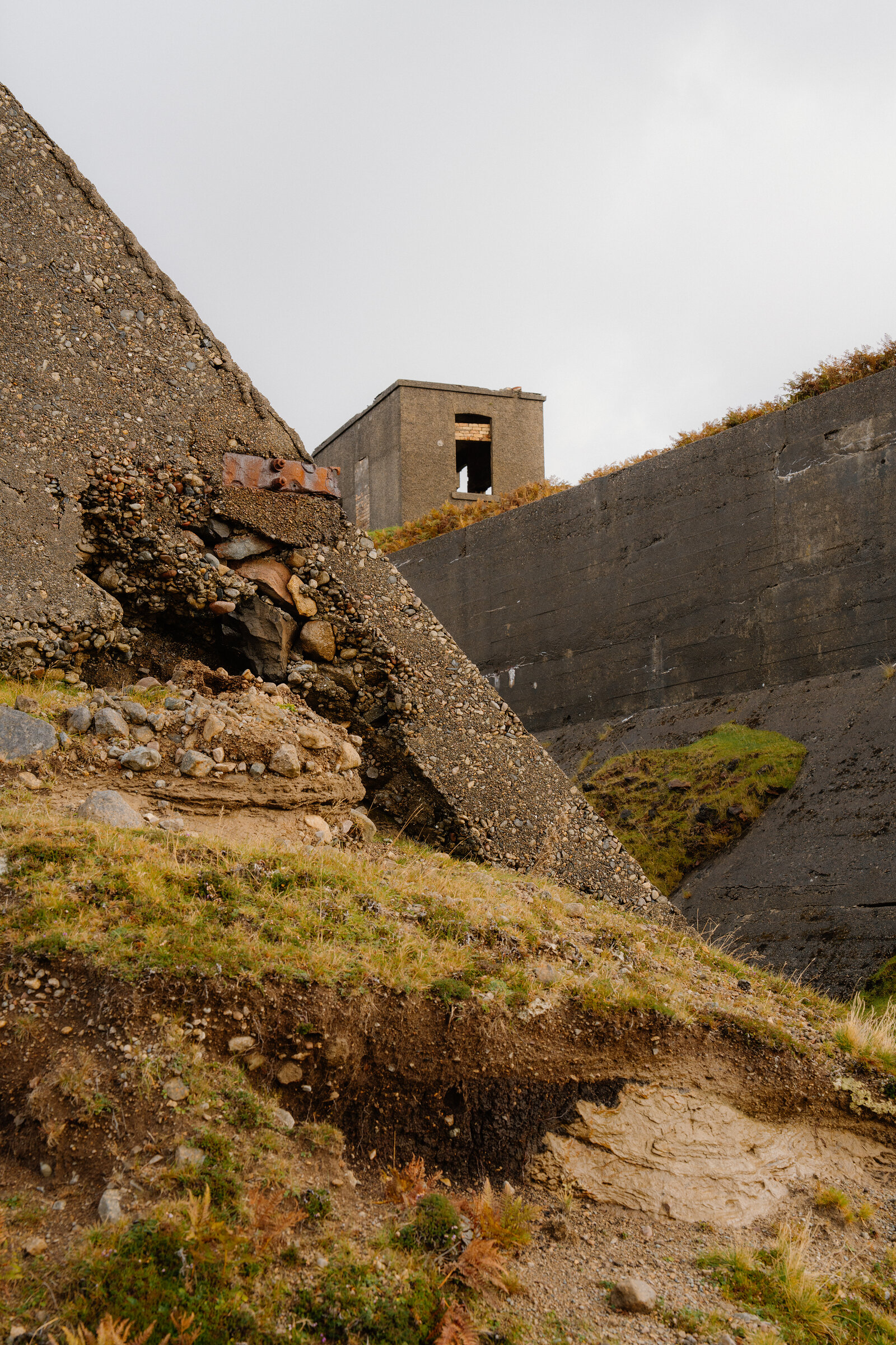 A rusted metal fitting juts from a crumbling concrete structure on the Isle of Skye.