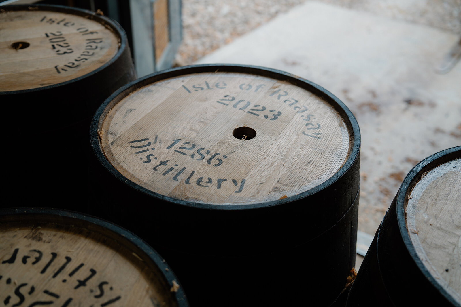 A whisky barrel stencilled Isle of Raasay Distillery sits among other casks.