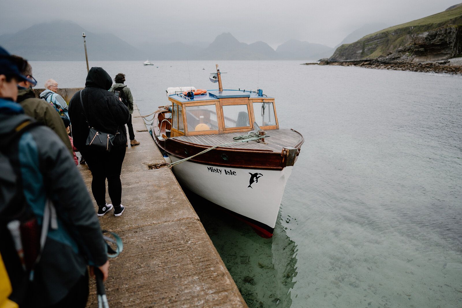 The Misty Isle boat is moored at a stone pier, passengers waiting to board on the Isle of Skye.