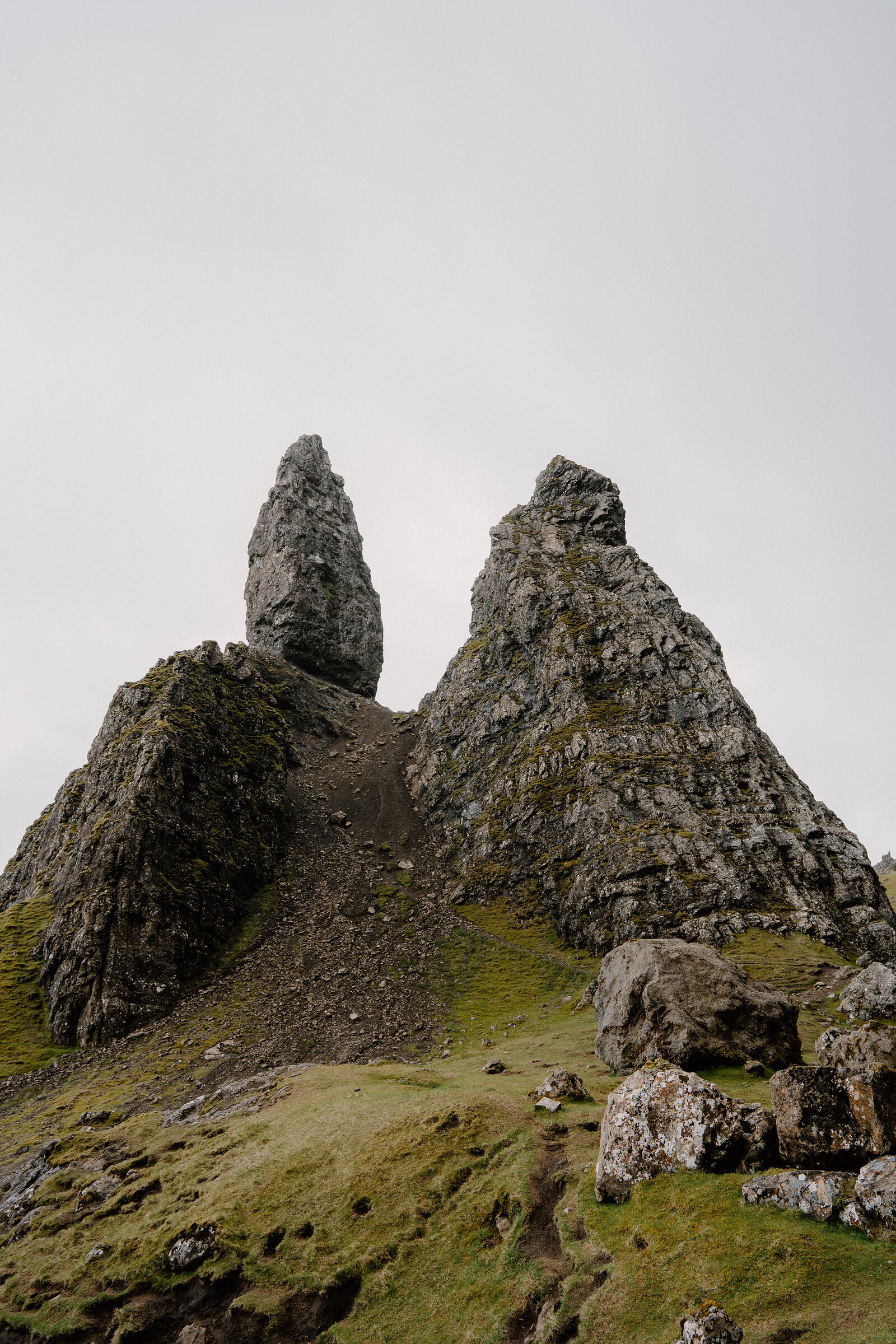 The Old Man of Storr's pinnacle rises beside jagged rocks and a scree slope on the Isle of Skye.