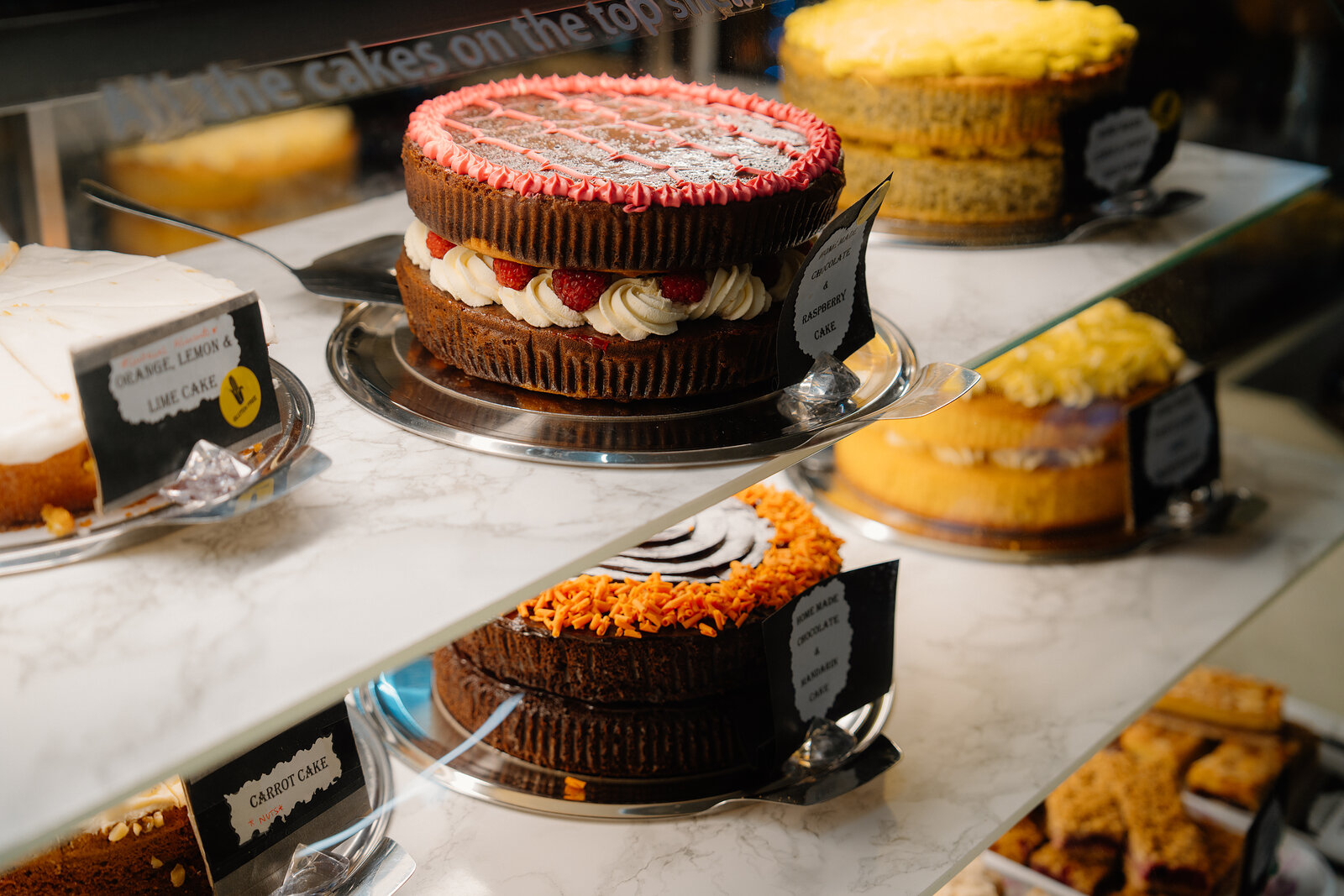 Amy's Place Tea Room's display counter holds a red velvet cake and other whole cakes on cake stands.