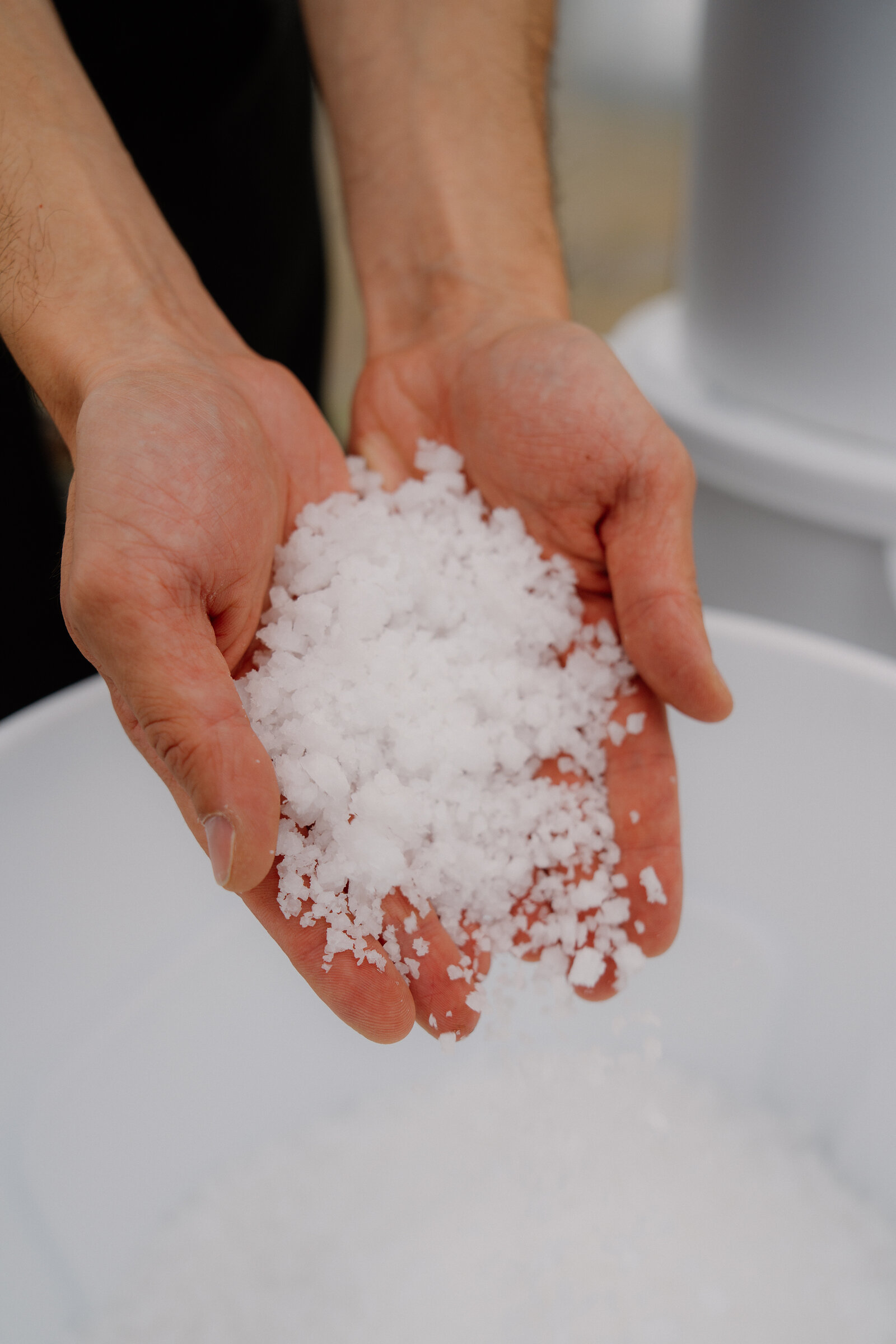 Cupped hands hold a mound of harvested sea salt crystals at Isle of Skye Sea Salt Company.