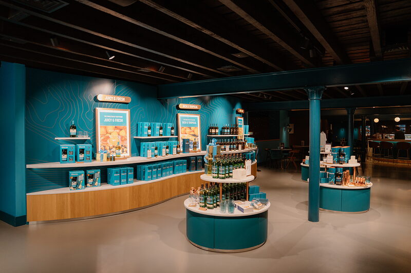 A teal-branded Singleton shop display lines the wall with bottles, boxes and merchandise.