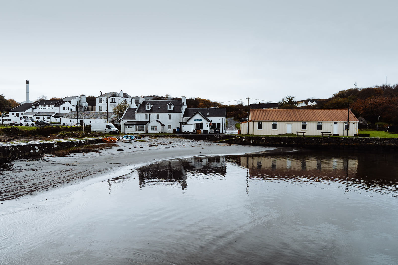 Craighouse across the bay at low tide, white houses reflected in the water.