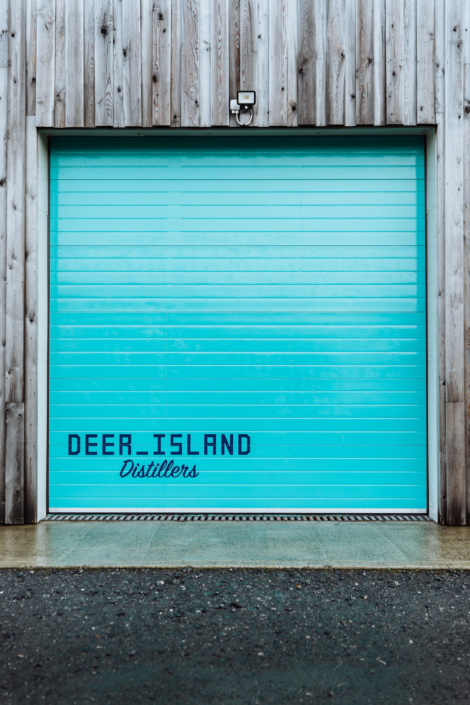The turquoise roller door of Deer Island Distillers at the Pier Garage.