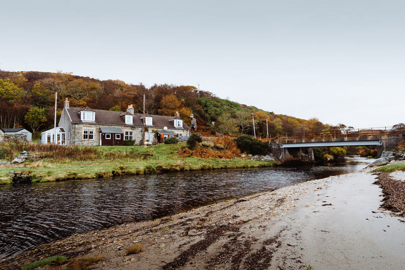 The white cottages of Inverlussa along the shore where the river meets the bay.