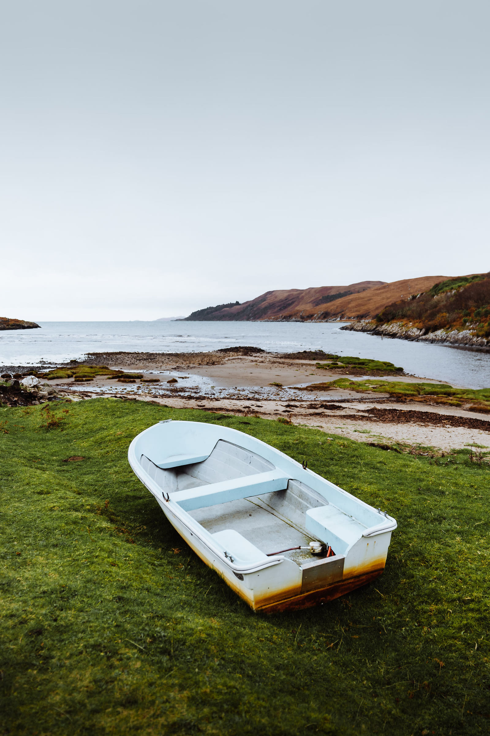 A small boat pulled up on the grass by the river mouth at Inverlussa.
