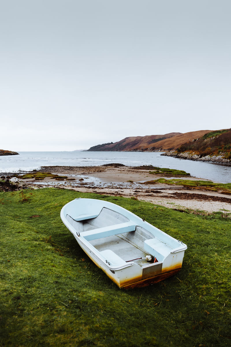 A small boat pulled up on the grass by the river mouth at Inverlussa.