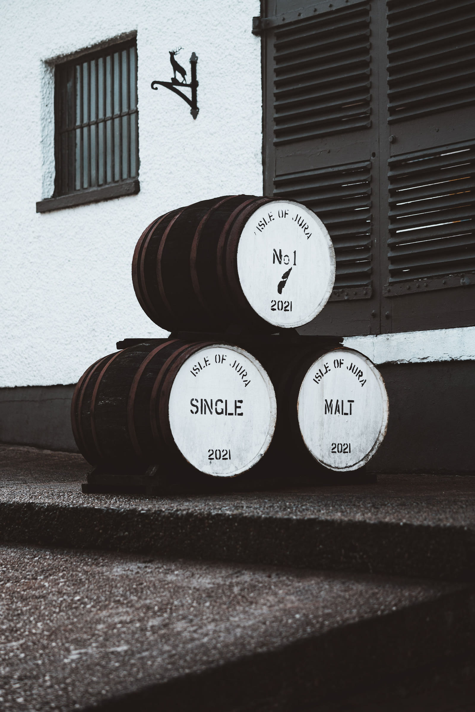 Casks stacked outside the distillery, marked Isle of Jura Single Malt.