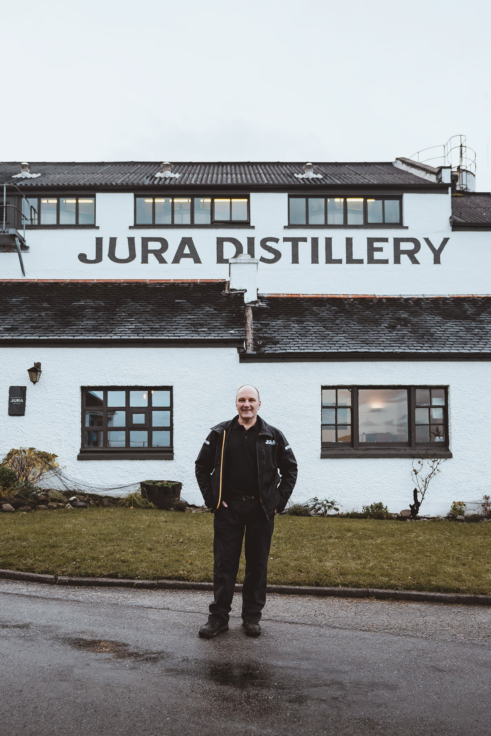 A distillery worker on the lawn in front of the Jura Distillery.