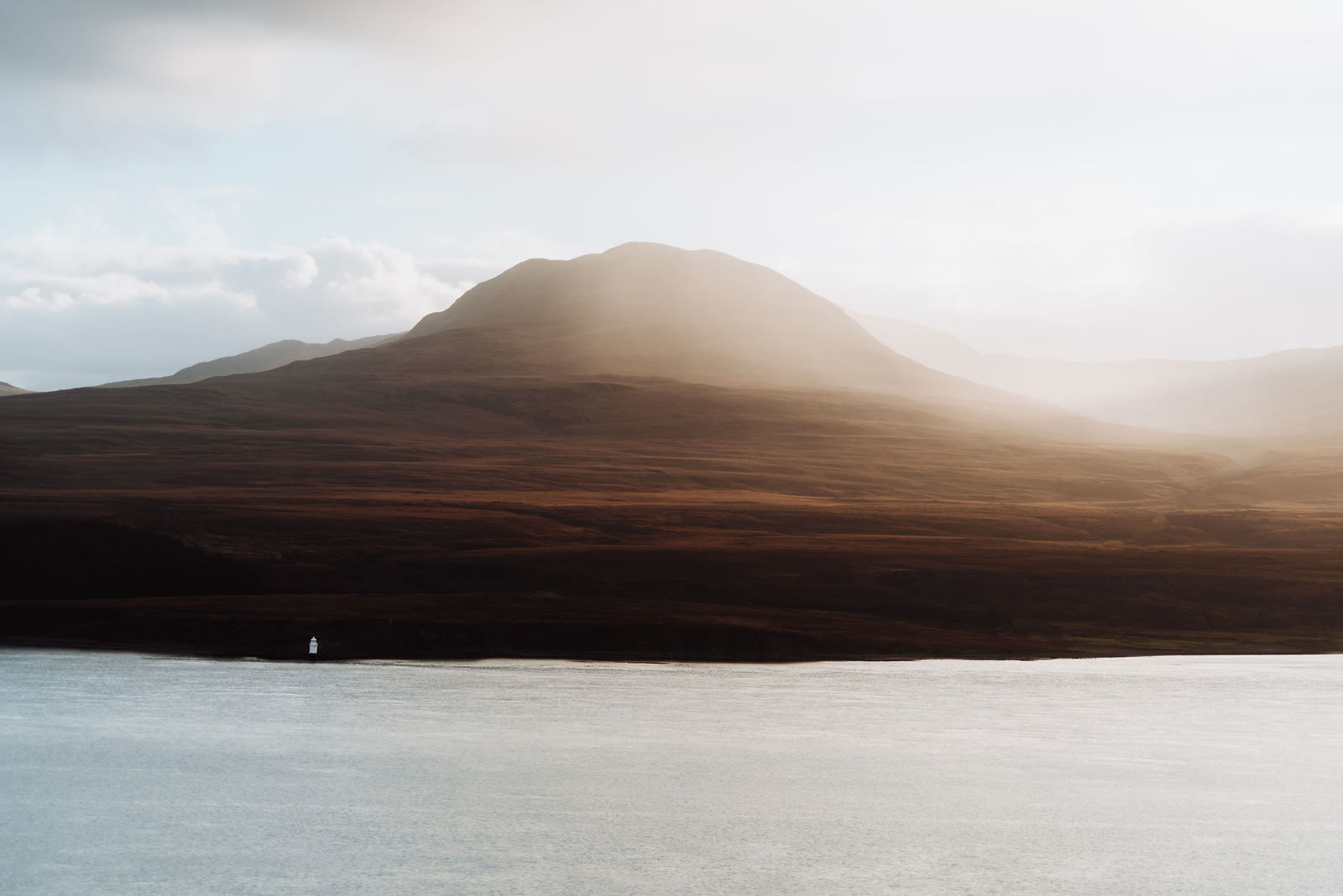 One of the Paps of Jura in low sunlight and haze across the Sound of Islay.