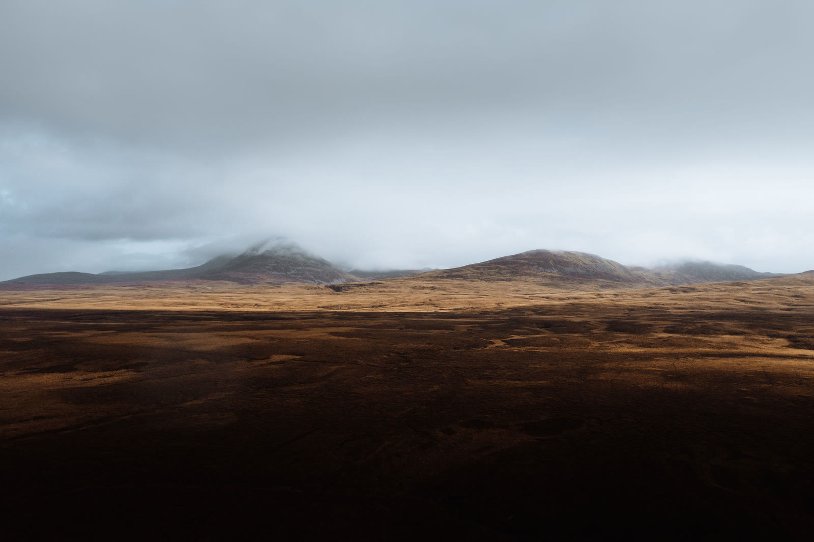 The Paps of Jura in cloud beyond a wide brown moor.