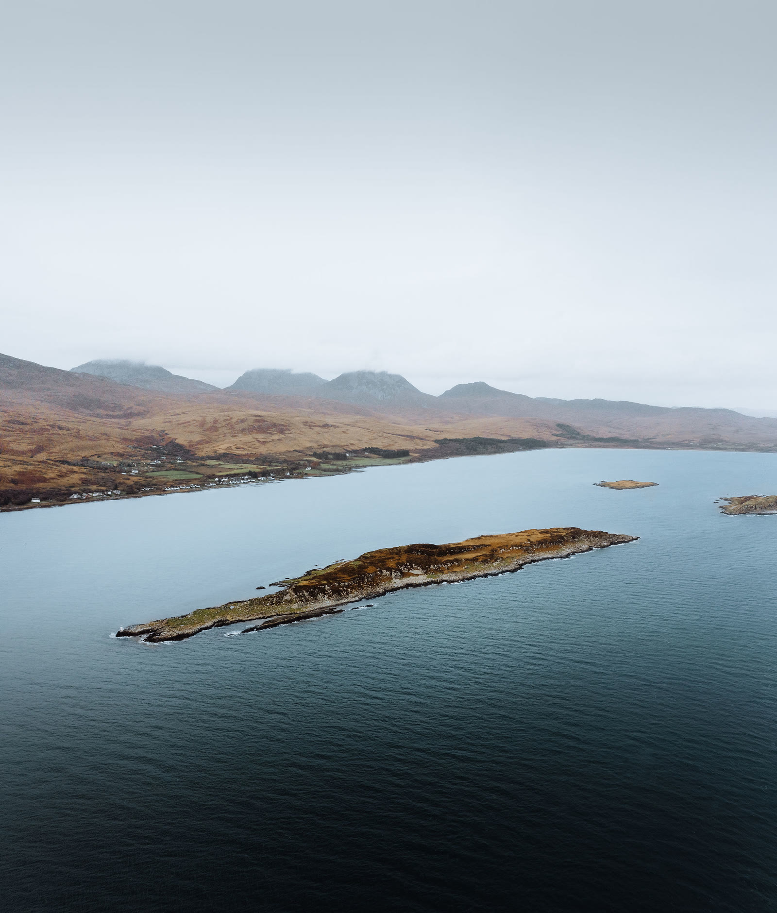 One of the Small Isles off Craighouse from the air, Jura's hills behind.