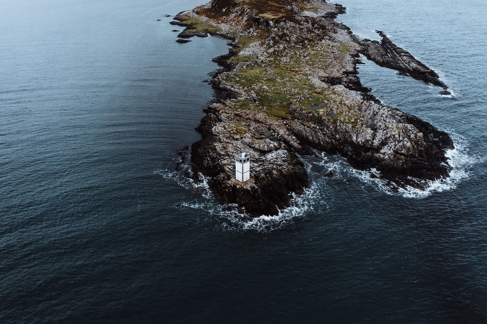 Surf round the rocks of an islet in Small Isles Bay.
