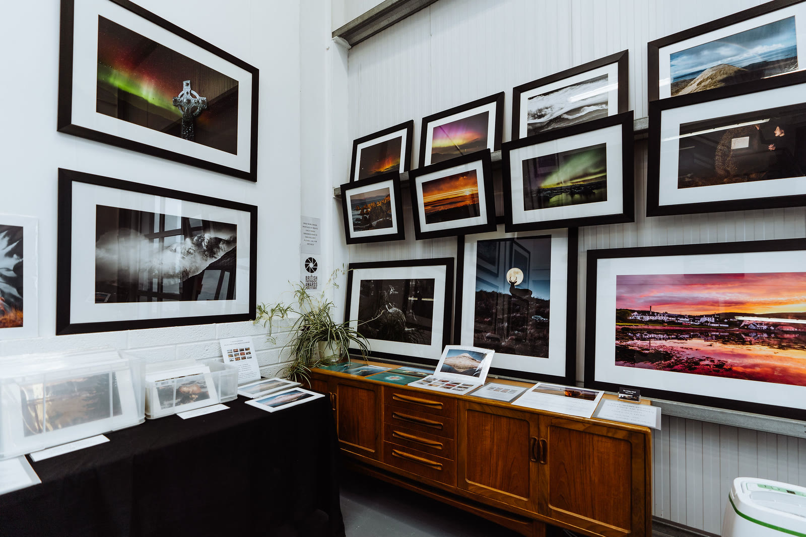 Framed landscape photographs covering a wall of the gallery.