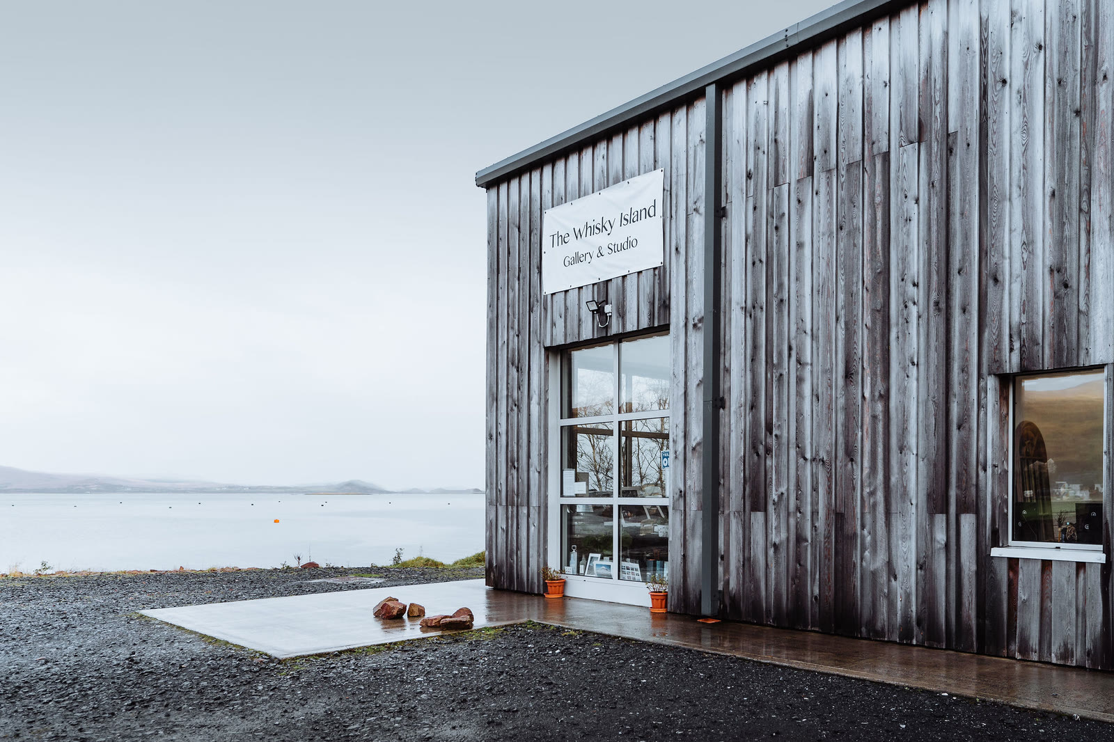 The Whisky Island Gallery and Studio, a timber building above the bay at Craighouse.
