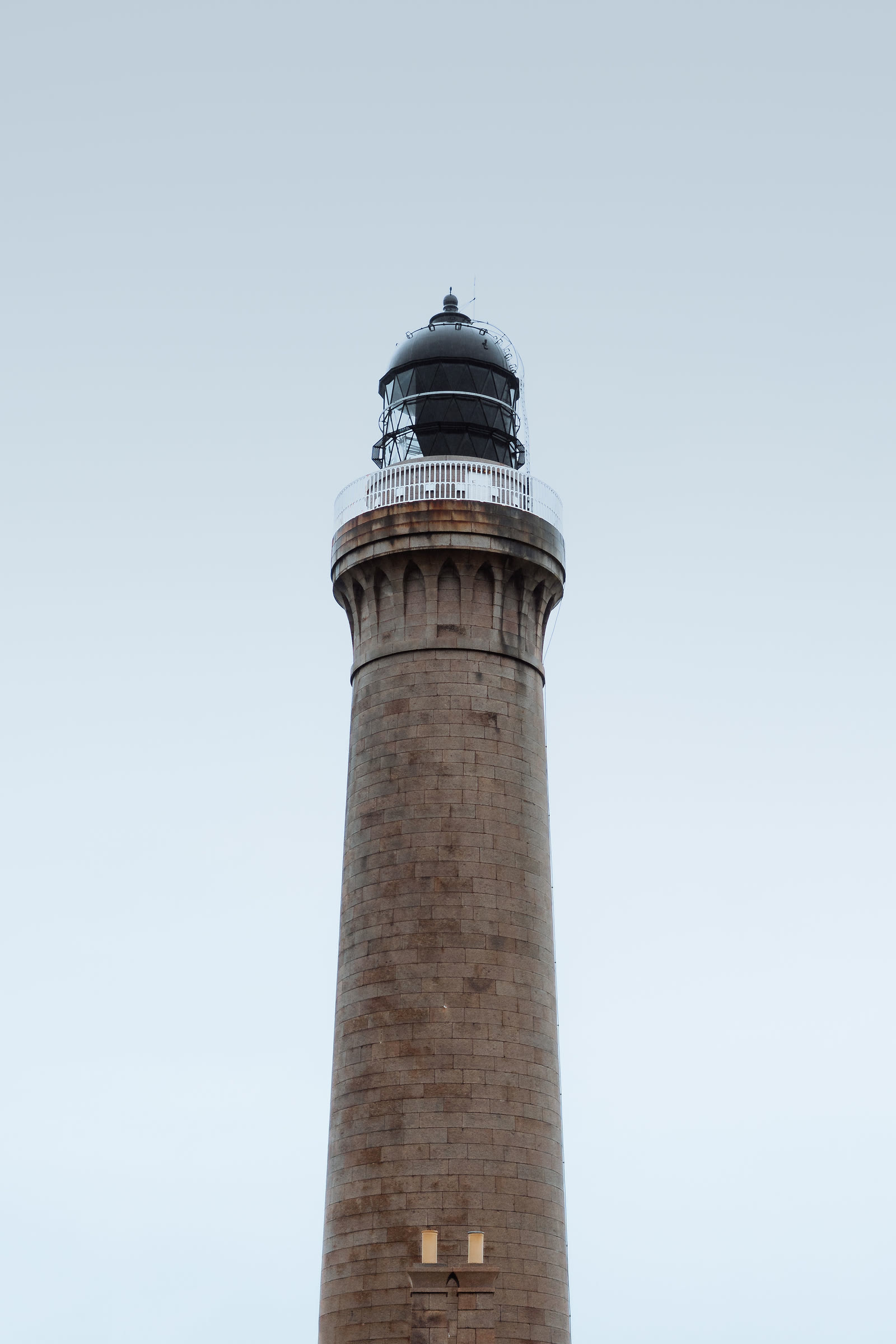The granite tower of Ardnamurchan Lighthouse against a pale sky.