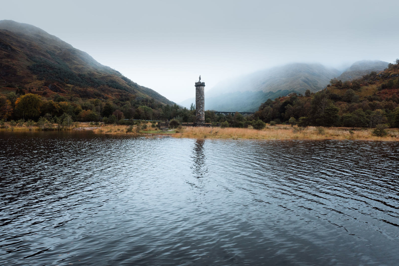 The Glenfinnan Monument seen across the dark water of Loch Shiel.