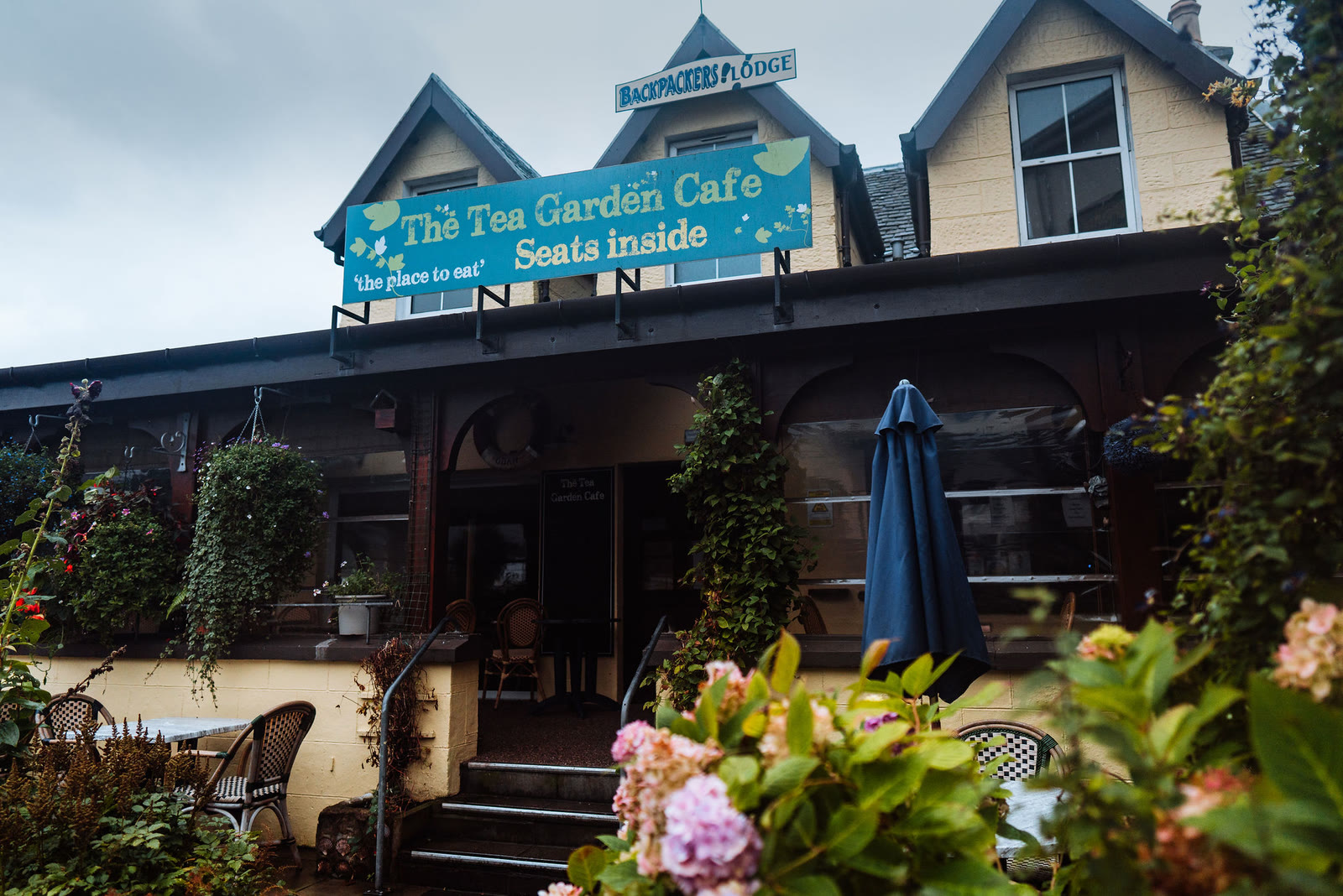 The Tea Garden Cafe in Mallaig behind its terrace and flowers.