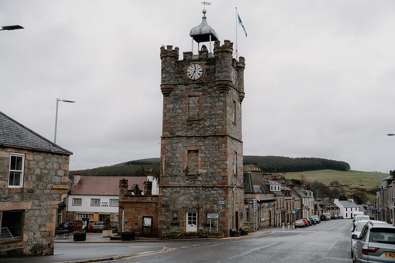 Dufftown's castellated clock tower stands at the centre of a quiet crossroads beneath wooded hills.