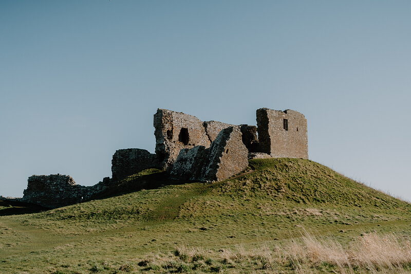 Duffus Castle's ruined stone keep on its grassy motte above the flat fields of the Laich of Moray.