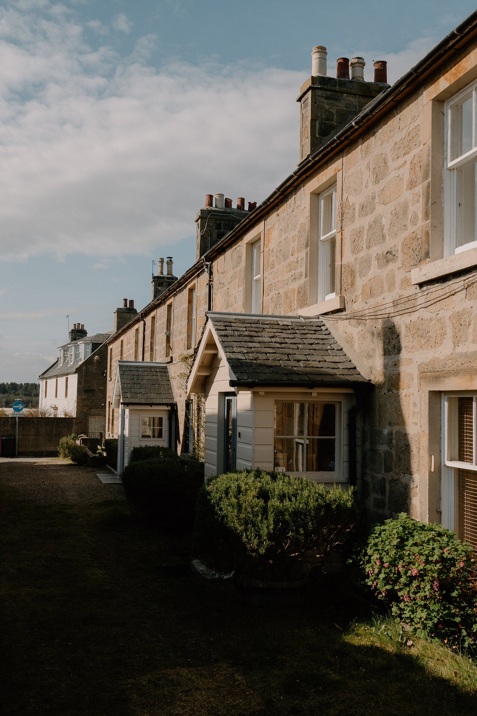 A row of stone terraced cottages catches the sun in a Moray village.