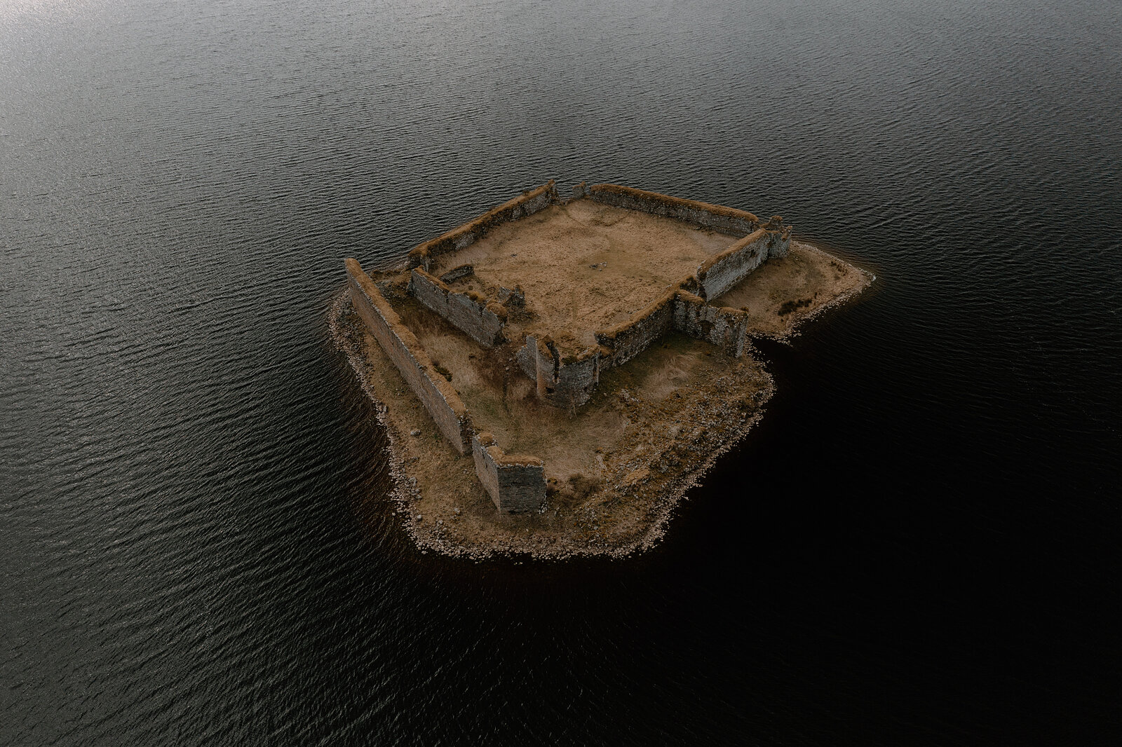 Lochindorb Castle's ruined walls stand on their island beneath a clouded sky, Moray.