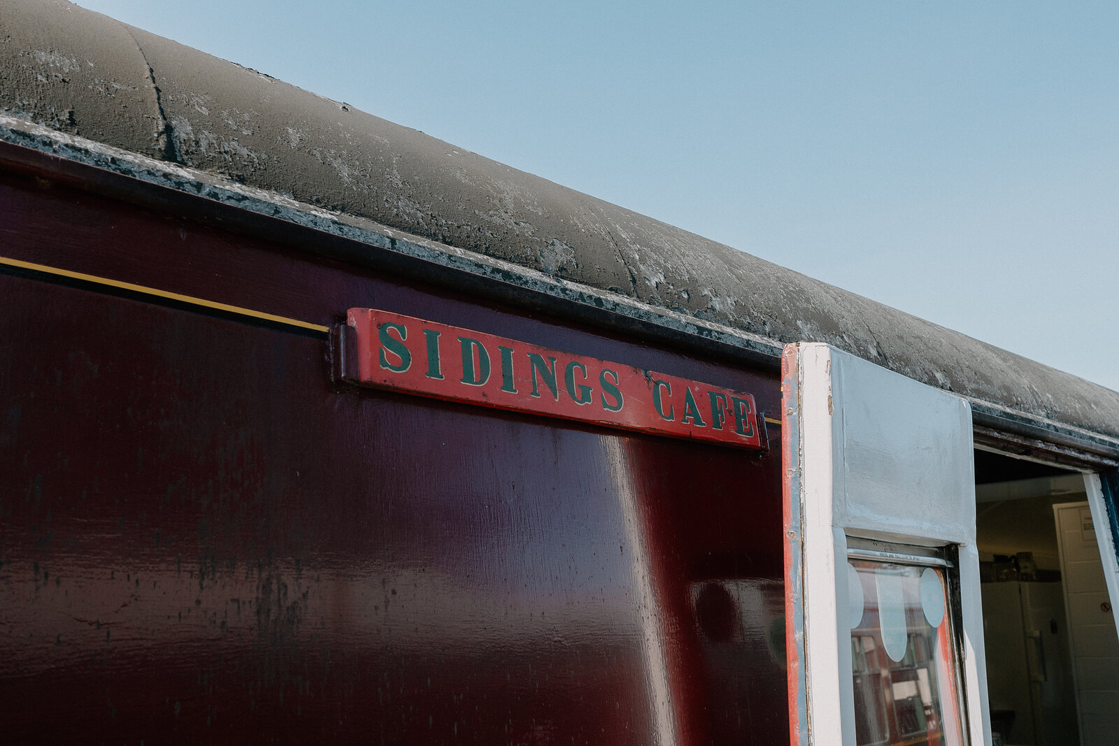 Sidings Café's sign is fixed to the maroon-liveried carriage that houses it.