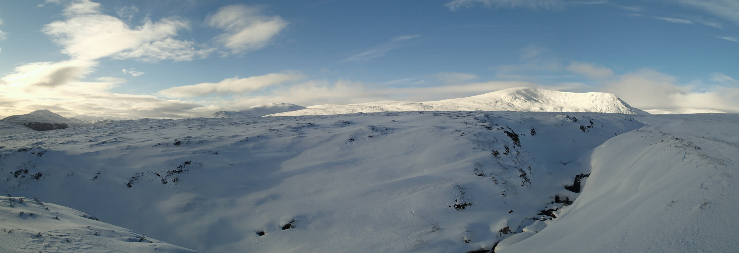 A' Chailleach under snow in low sun, seen across the snow-filled gully of the Allt na Beinne.