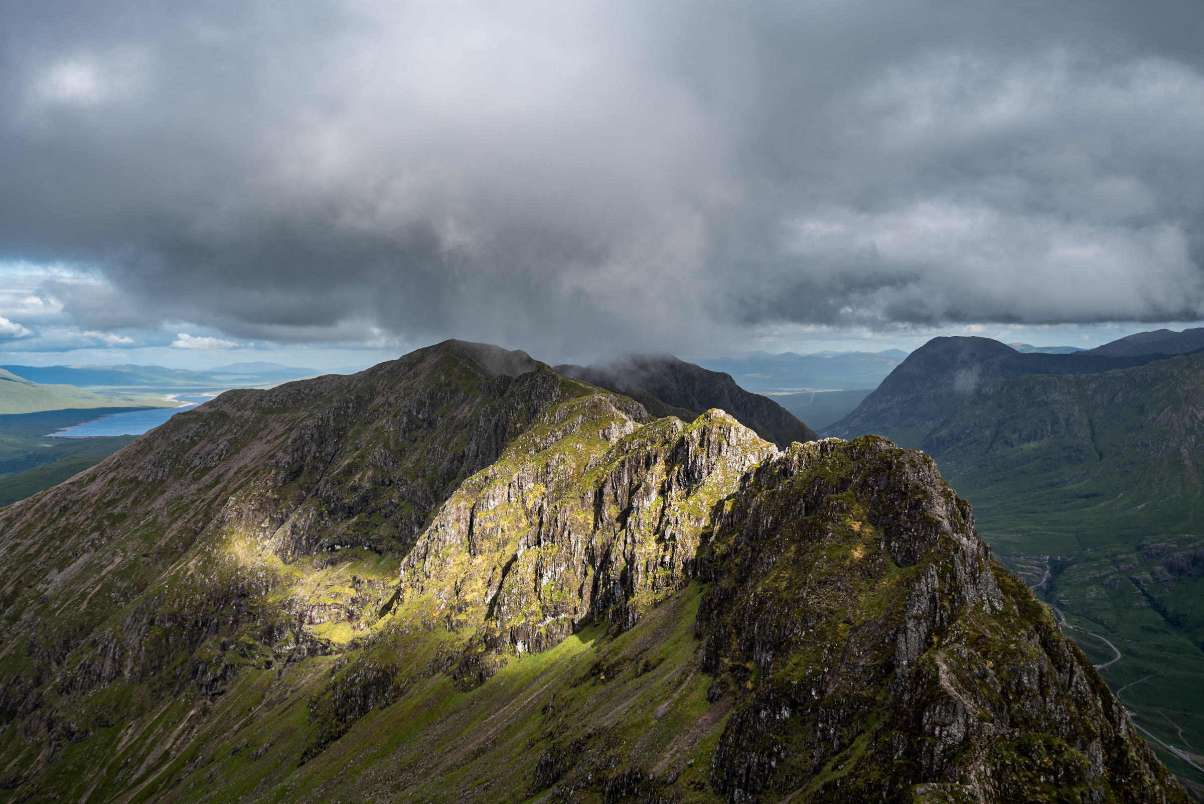 Sun breaking through cloud onto the Aonach Eagach.