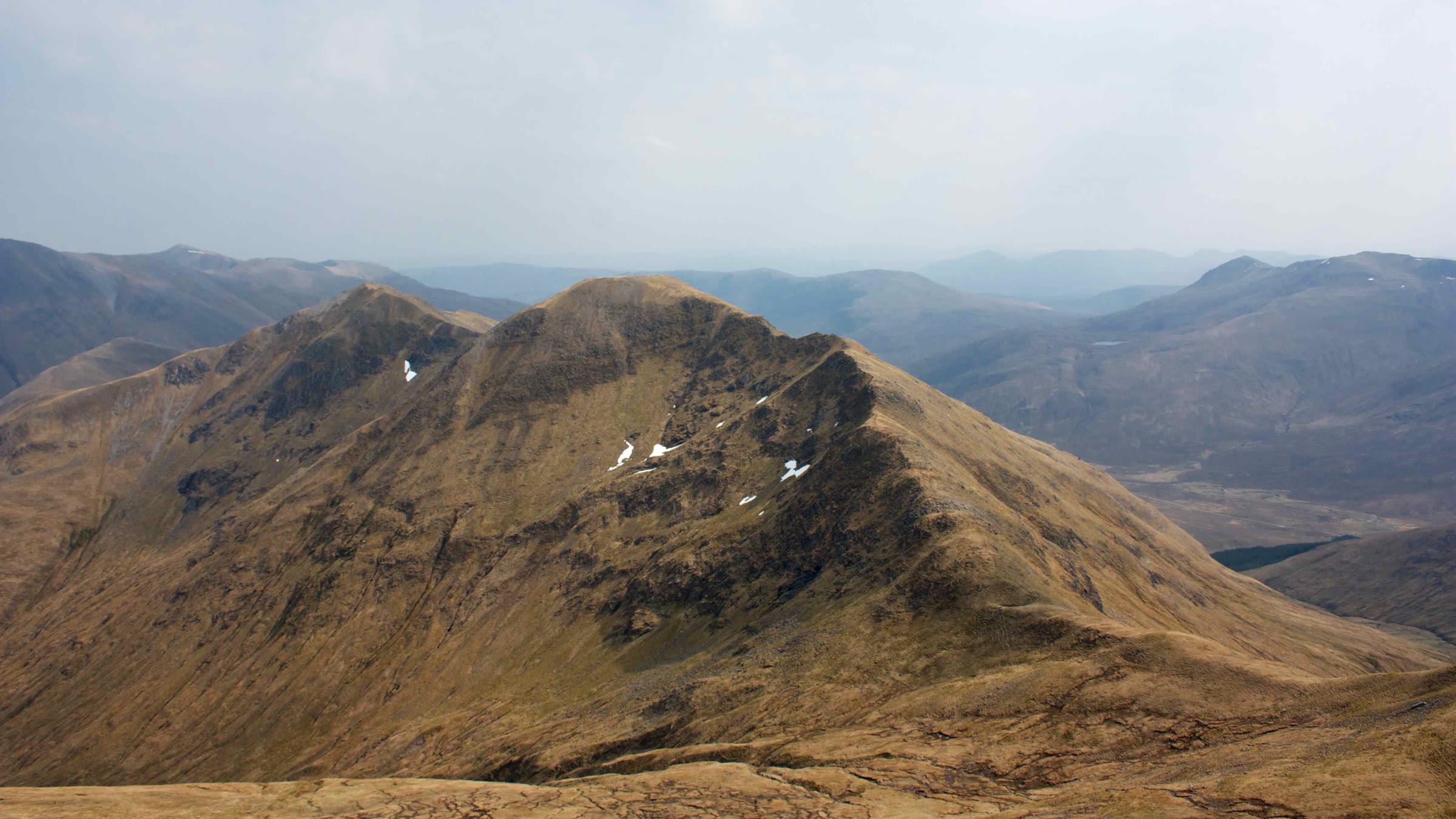 Aonach Meadhoin in spring, tawny slopes with the last snow patches under its top.