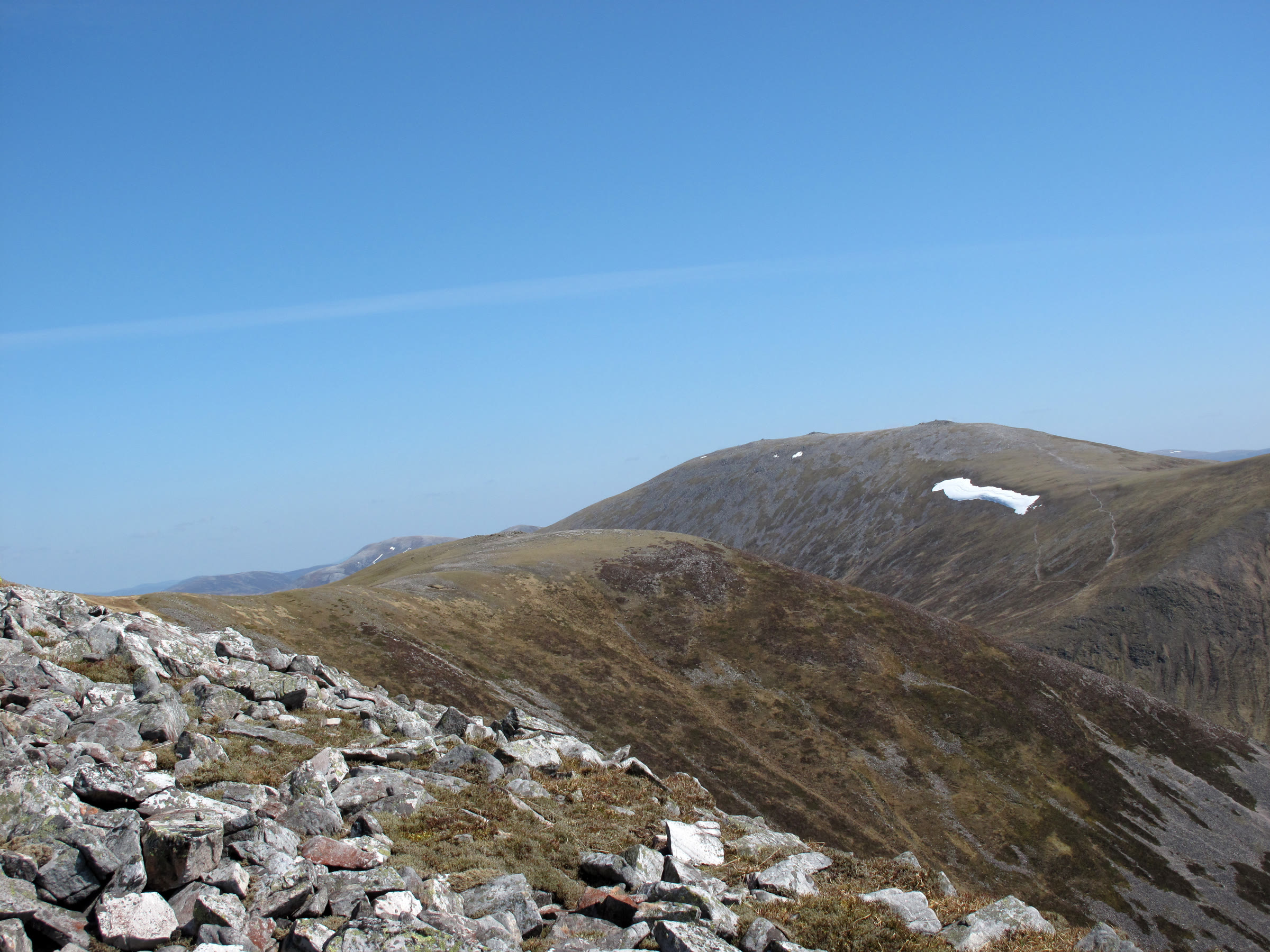 A late snow patch high on one of the Beinn a' Ghlò hills, seen over summit stones.