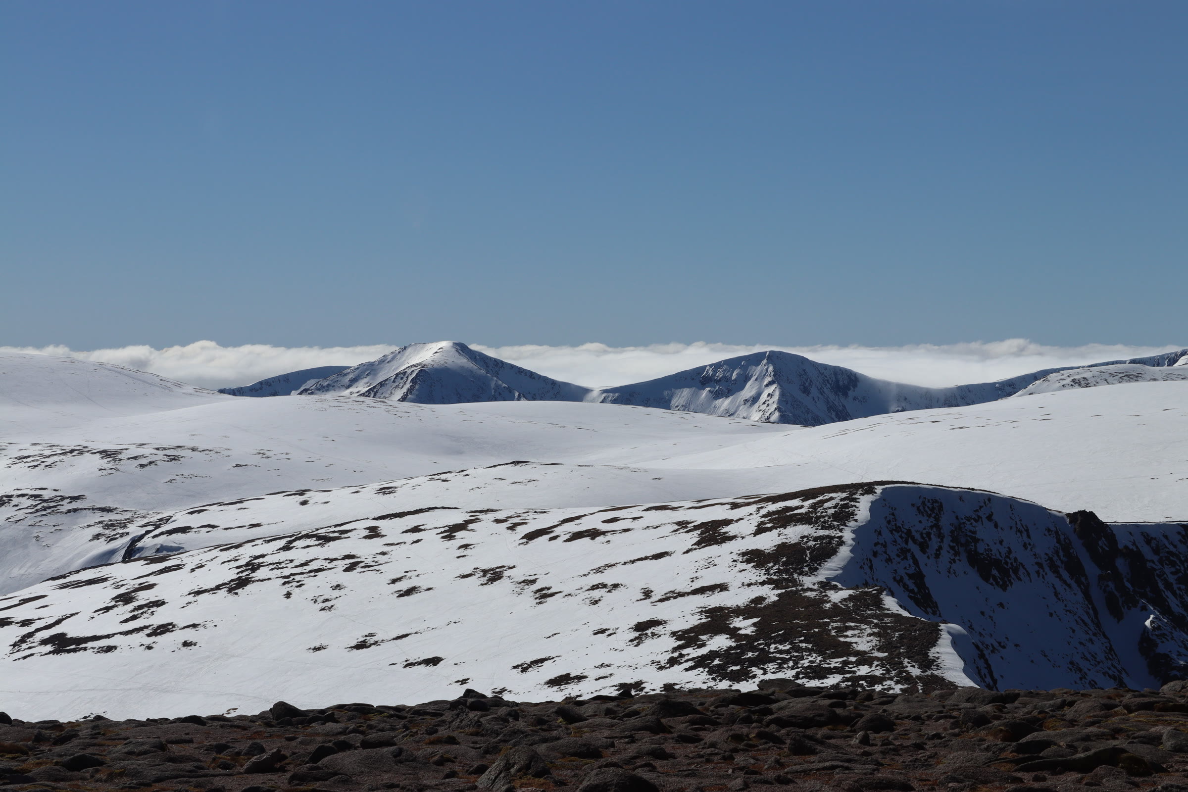 Cairn Toul and the Angel's Peak under snow, rising above a sea of cloud across the Cairngorm plateau.