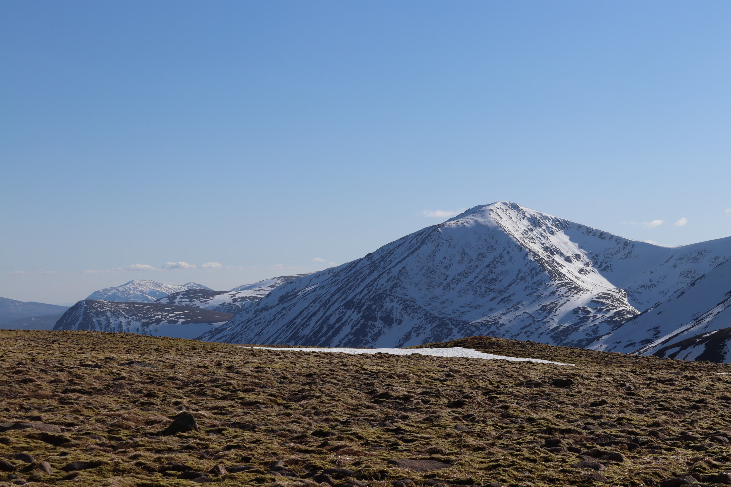 Cairn Toul under snow against a clear sky, the Devil's Point below it.