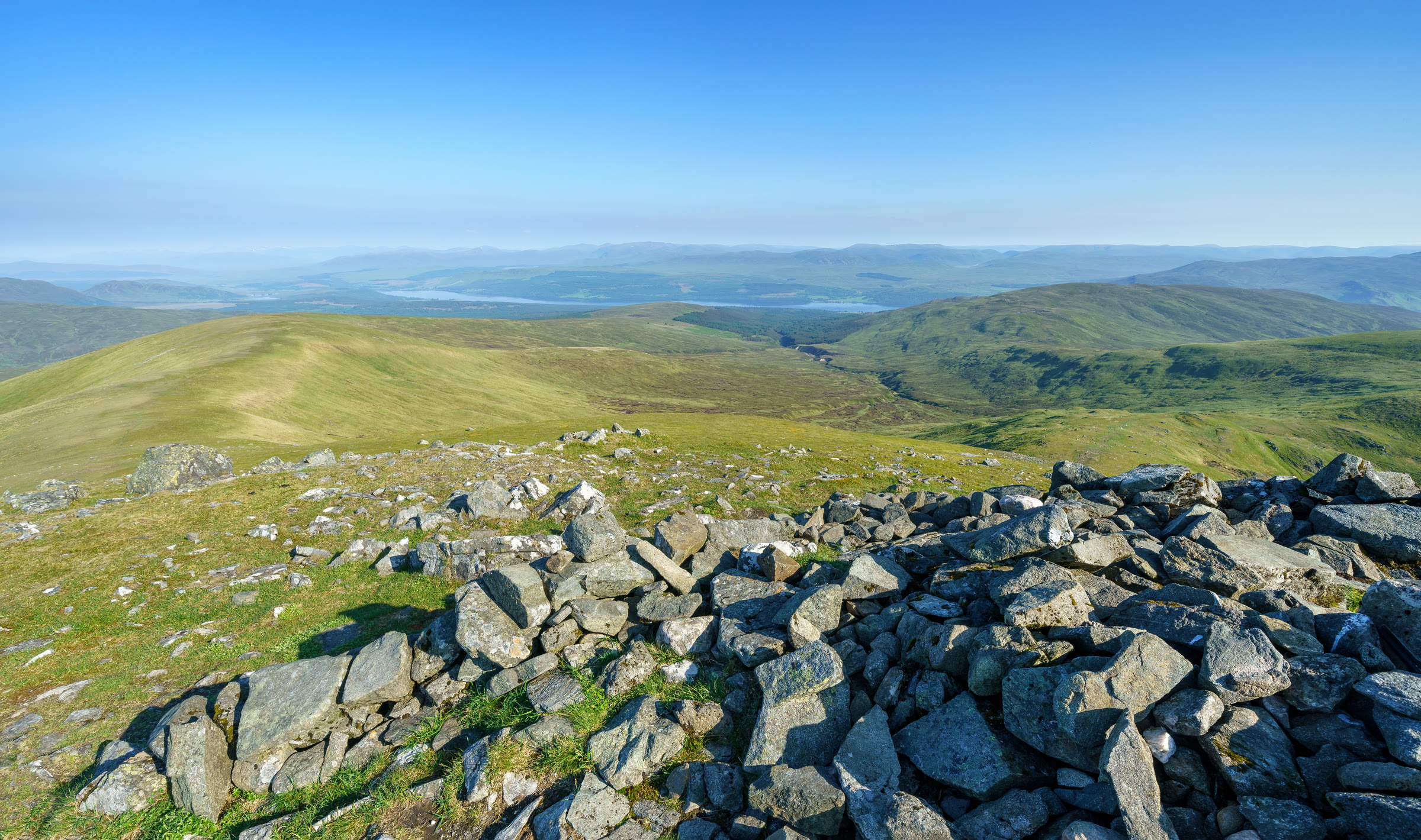 Stones on the top of Càrn Gorm, with Loch Rannoch in the distance.
