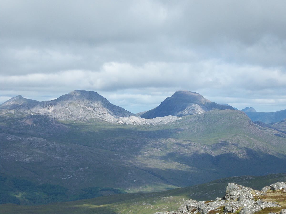 Maol Chean-dearg on the left and An Ruadh-stac on the right, seen across the Coulin Forest under a heavy sky.
