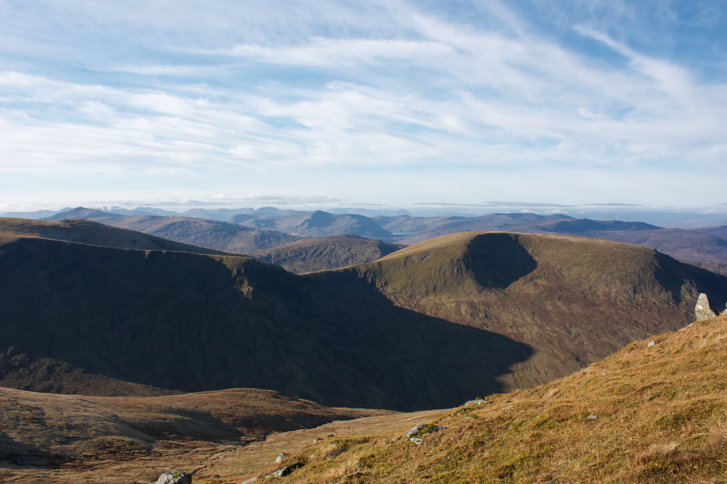 The rounded top of Meall a' Choire Lèith with a shadowed corrie on its near side, hills ranged beyond.