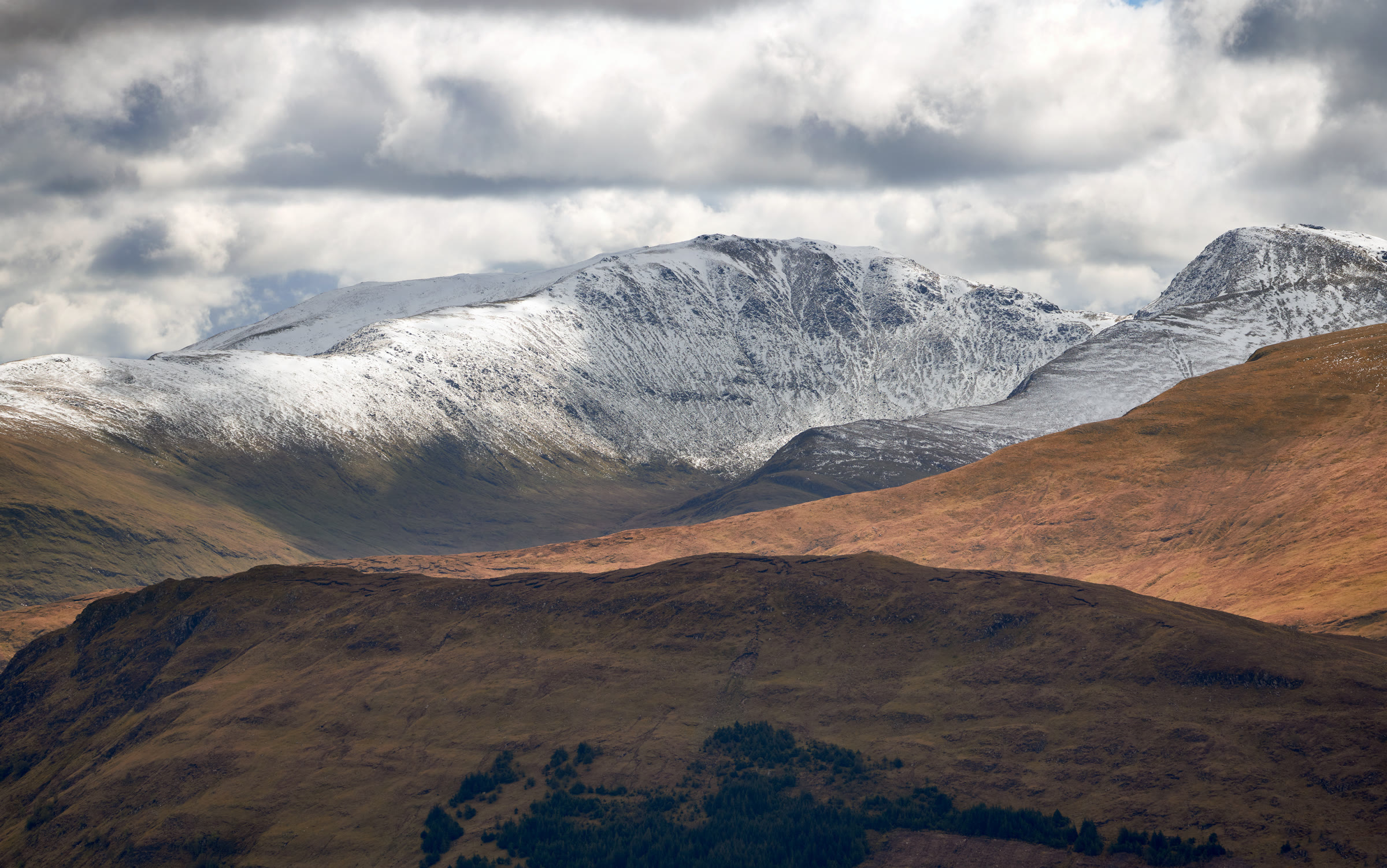 Meall Garbh on the left and An Stùc to its right under fresh snow, beyond brown moorland ridges.