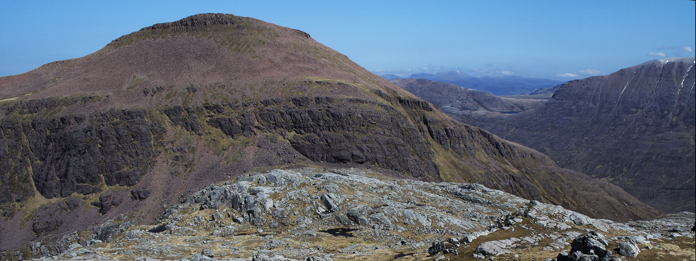 The red, crag-banded bulk of Ruadh Stac Mòr under a blue sky.