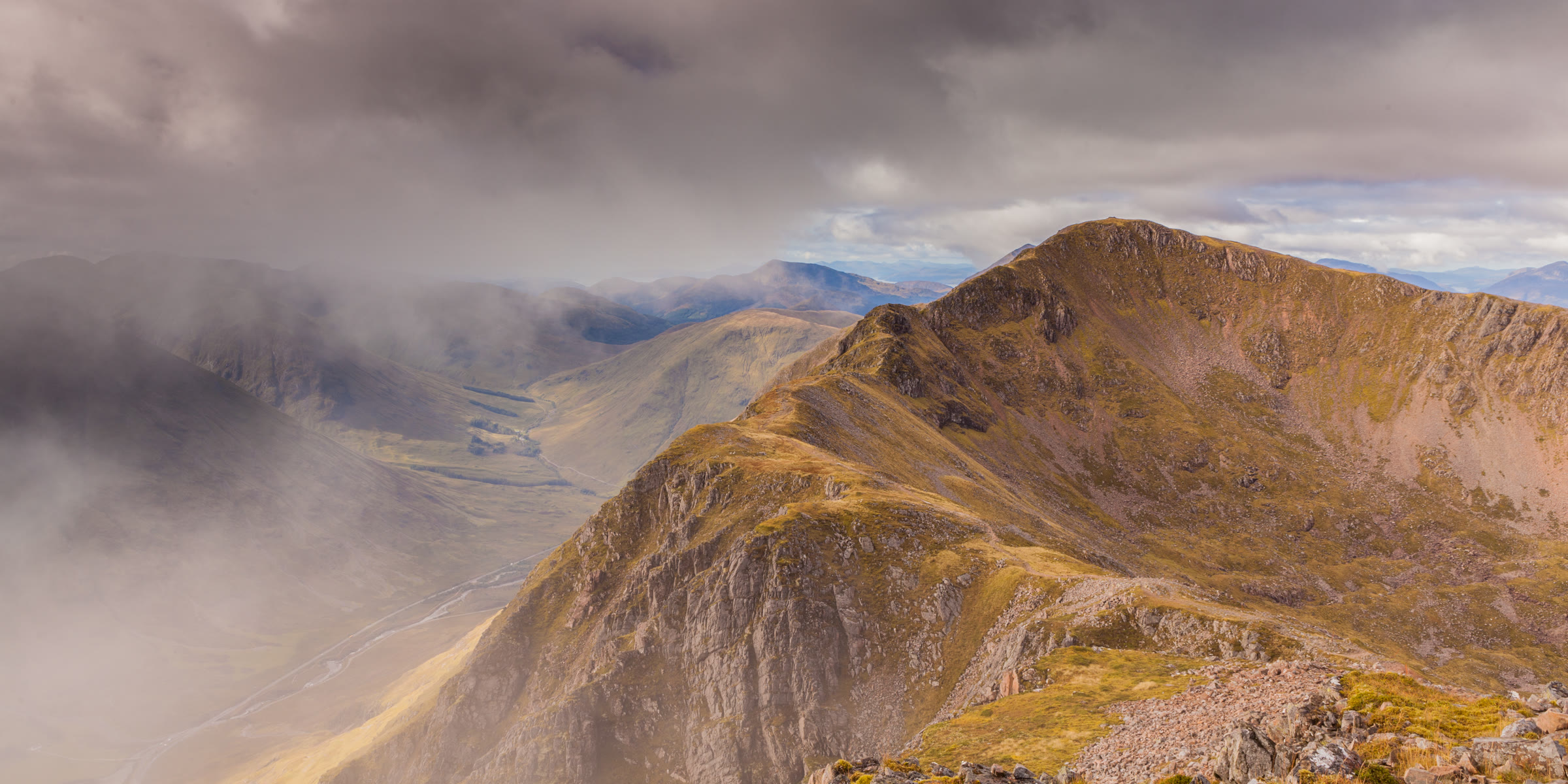 Sgòrr nam Fiannaidh from the Aonach Eagach, its ridge lit brown between banks of cloud.