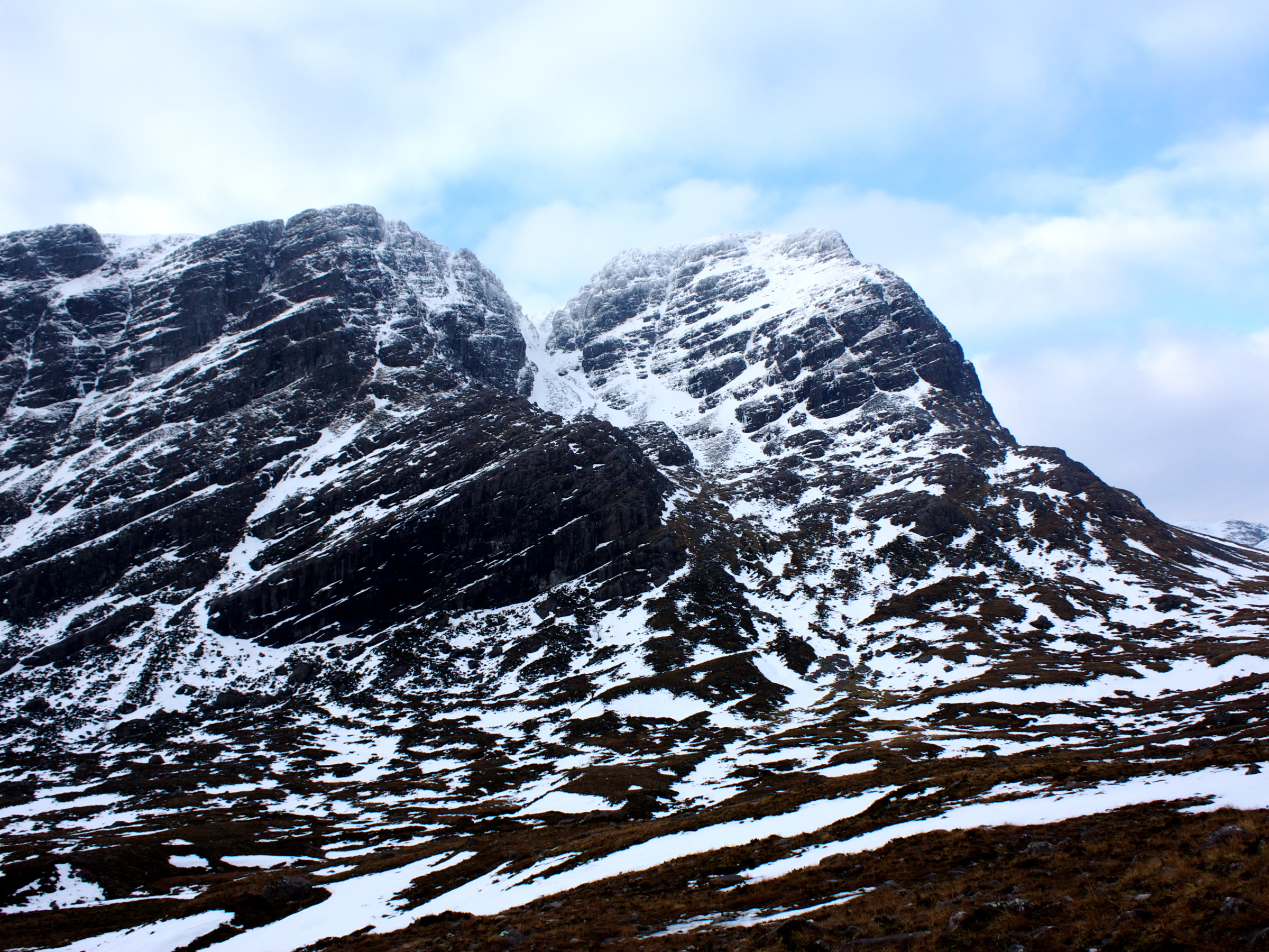 The banded crags of Sgòrr Ruadh under snow.