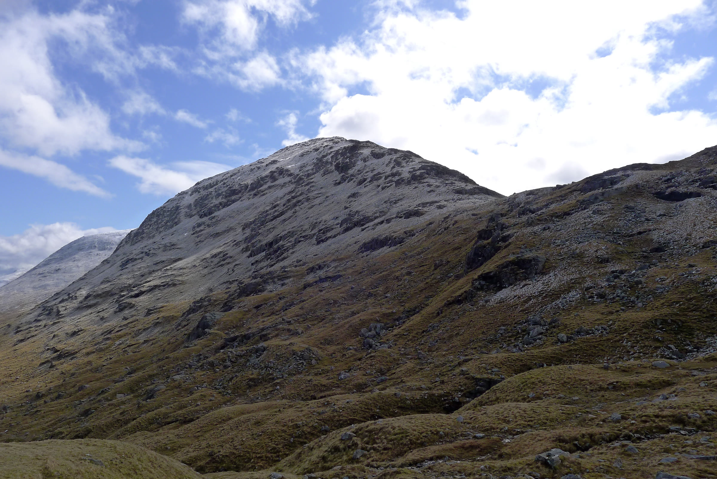 The frosted west ridge of Sgùrr Choinnich above a rough glen, under a blue sky.