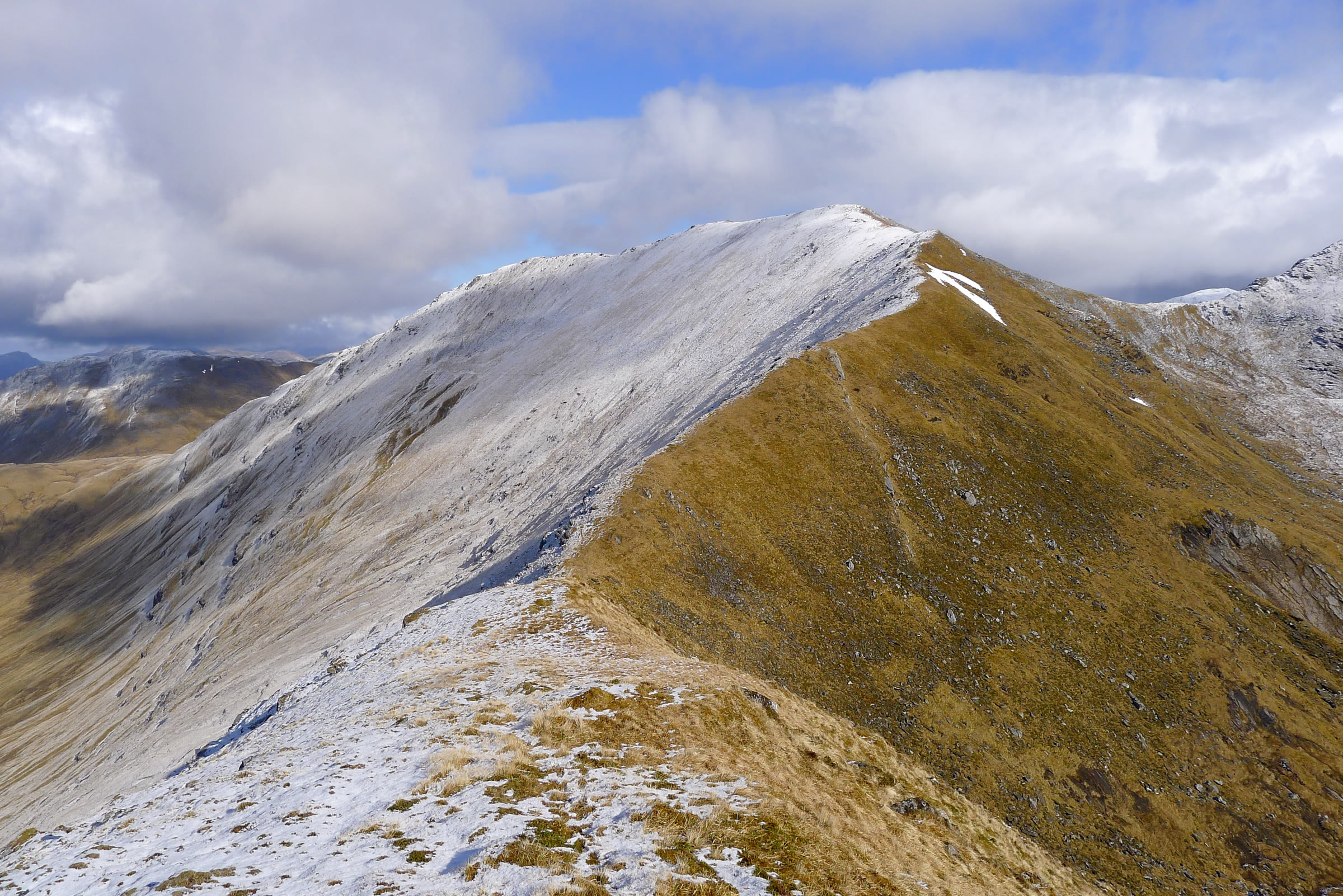 The narrow south ridge of Sgùrr Choinnich, frosted on one side and grassy on the other.