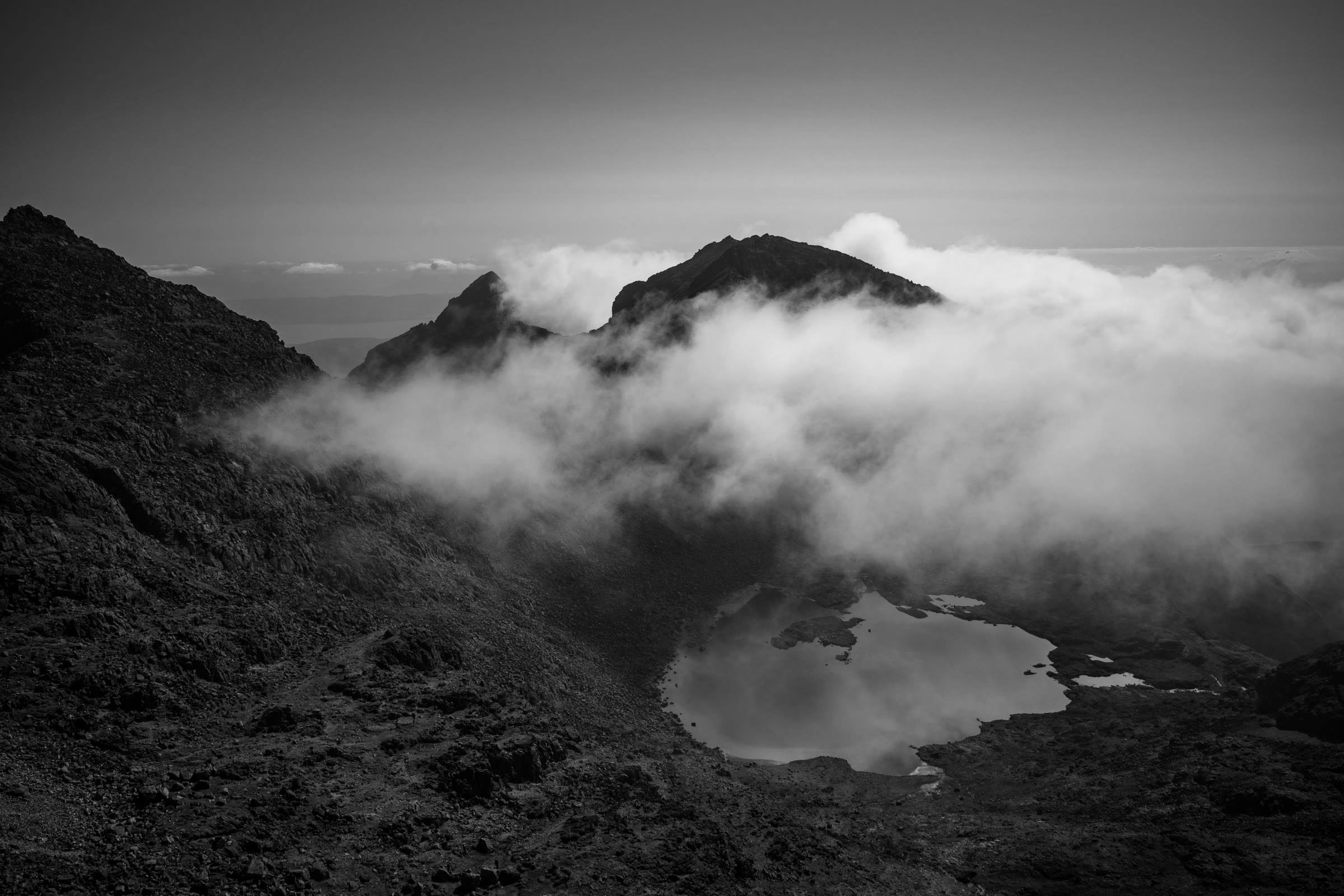 Cloud drifting round Sgùrr nan Eag above Loch Coir' a' Ghrunnda, in black and white.