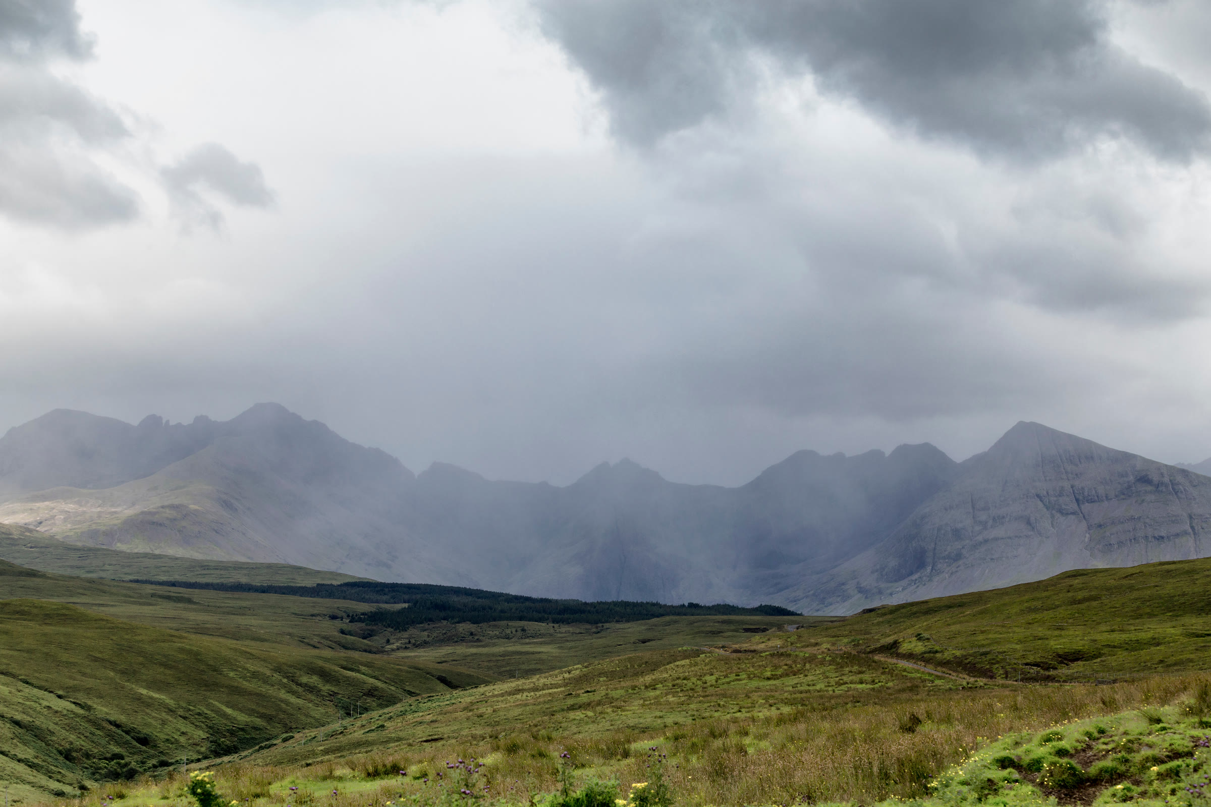 A summer shower hiding Bruach na Frìthe and the Cuillin above the glen of the Fairy Pools.