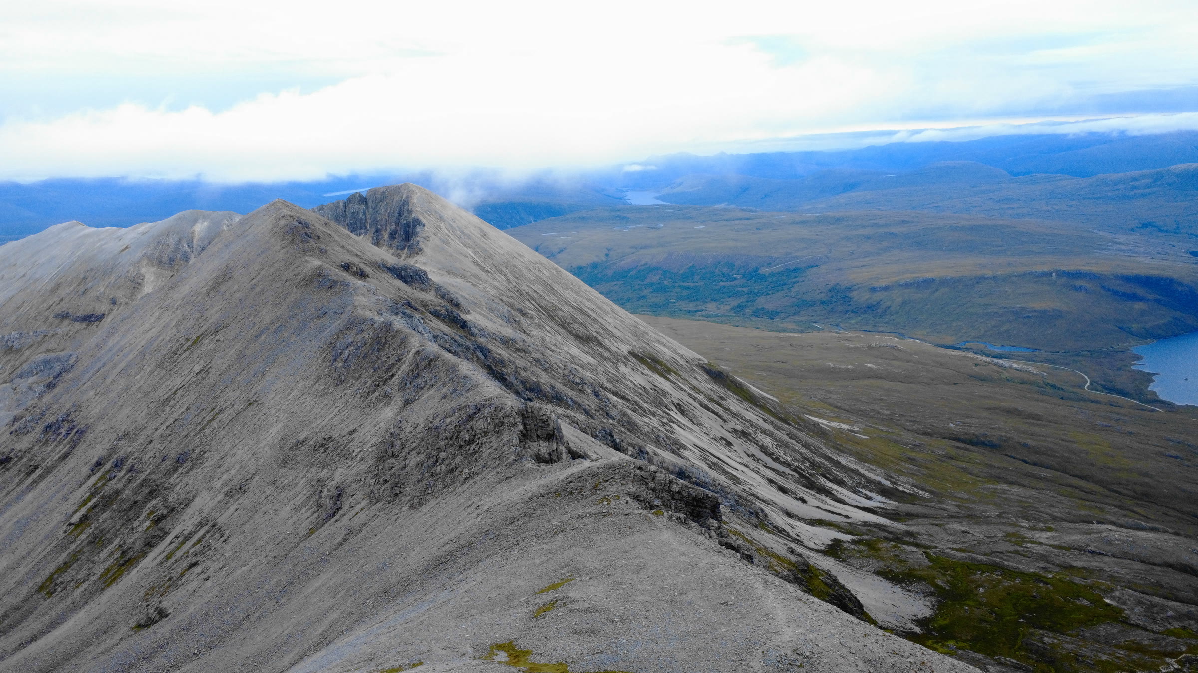The grey quartzite ridge of Beinn Eighe running out to Spidean Coire nan Clach, moorland and a loch far below.