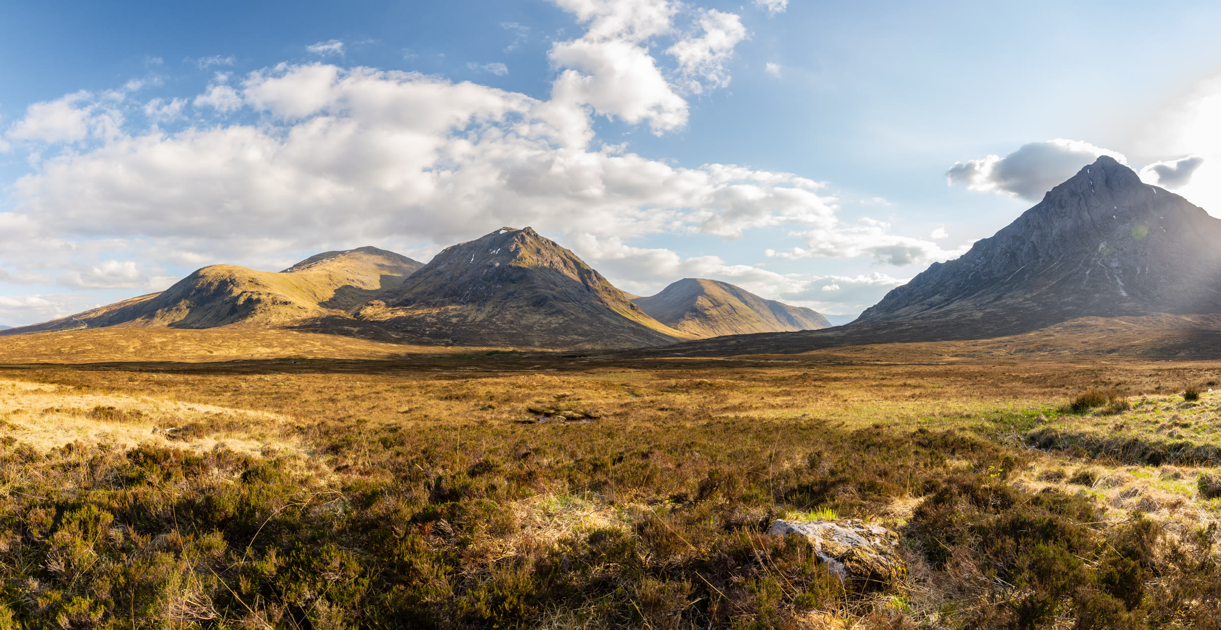 Sròn na Creise and Buachaille Etive Mòr across the heather of Rannoch Moor in warm light.