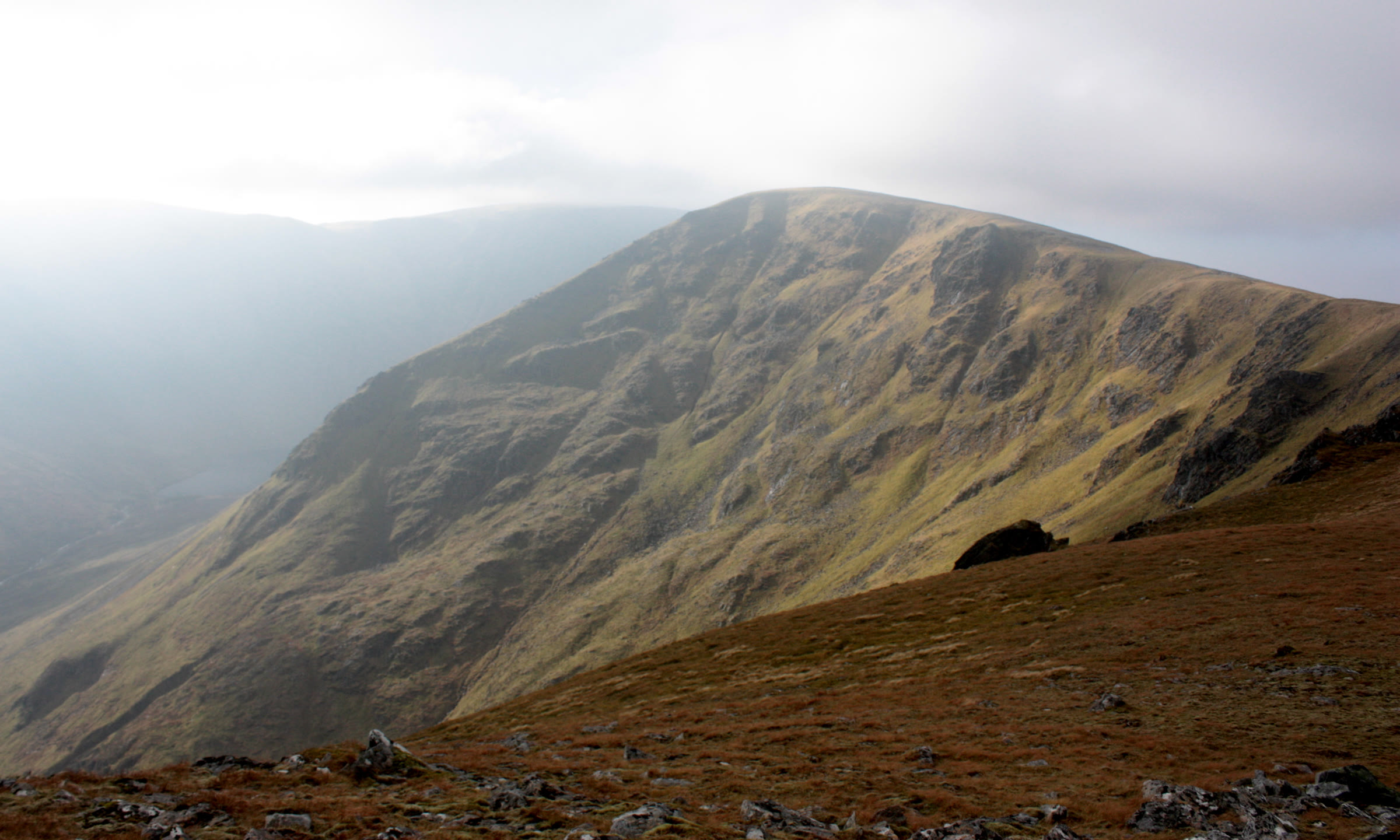 Stob Poite Coire Àrdair, its broad craggy flank in soft light with mist drifting across the glen to the left.